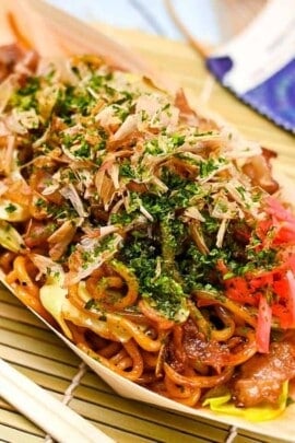 Festival style yakisoba served in a bamboo boat with red pickled ginger