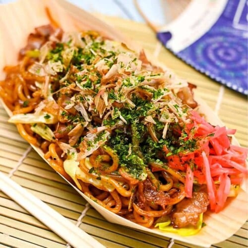 Festival style yakisoba served in a bamboo boat with red pickled ginger