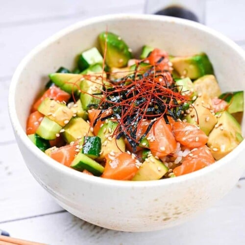 almon sashimi bowl (salmon donburi) in a white bowl topped with kizami nori and chili threads