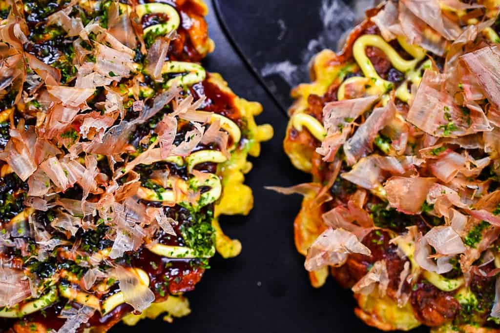 Two Japanese okonomiyaki pancakes side by side