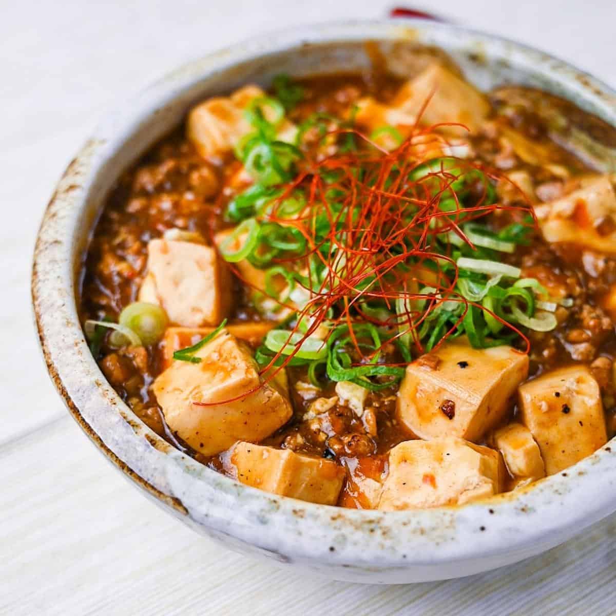 Japanese style mapo tofu topped with spring onion and chili threads