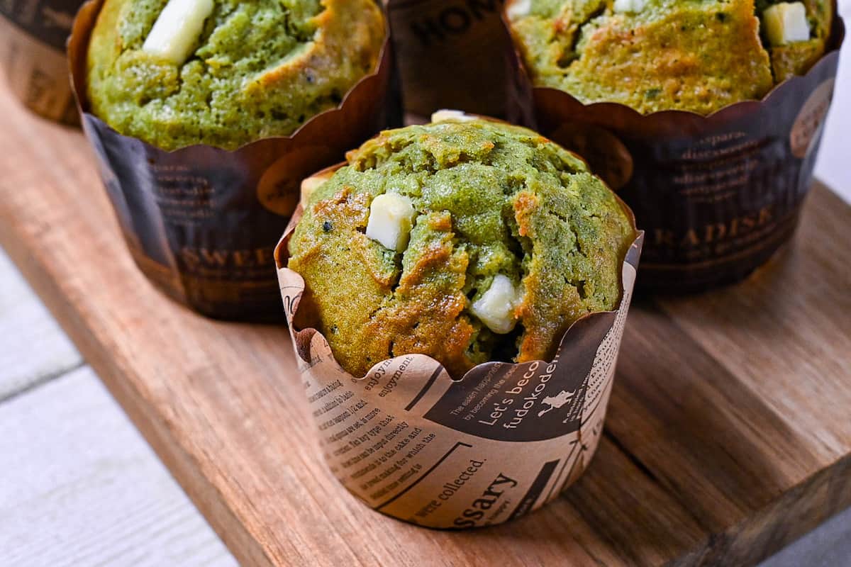 matcha and white chocolate muffin on a wooden chopping board