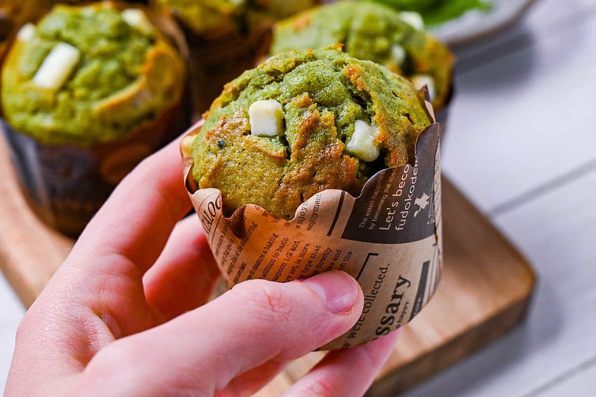 Matcha and white chocolate muffin held in hand