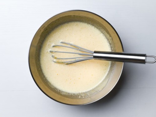 egg, sugar, milk, yogurt and vanilla essence mixed in a mixing bowl