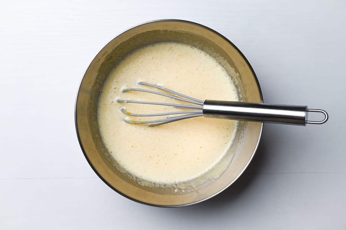 egg, sugar, milk, yogurt and vanilla essence mixed in a mixing bowl