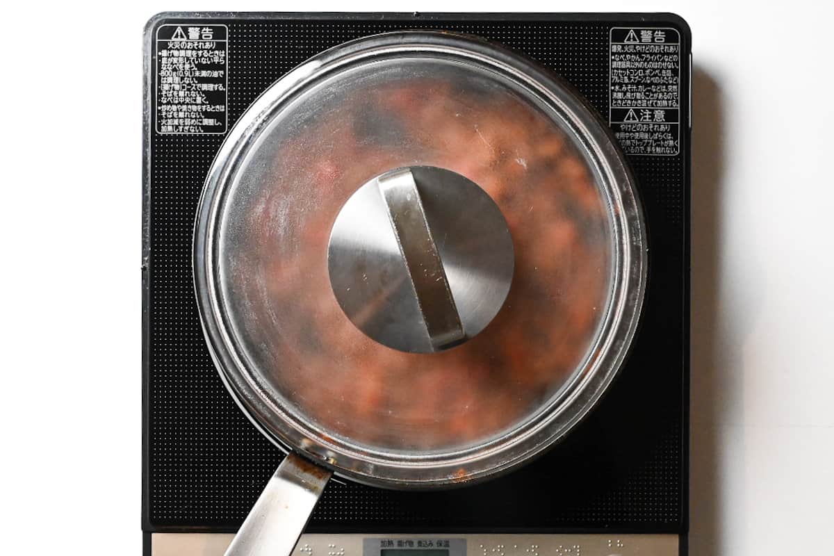 Milano doria meat sauce cooking in a frying pan with lid