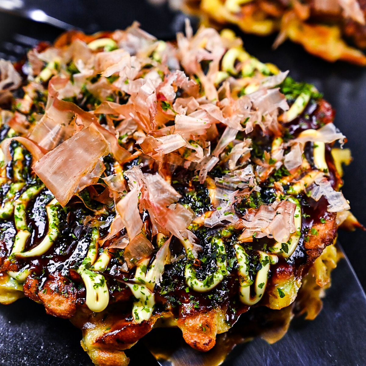 Osaka style okonomiyaki topped with homemade okonomi sauce, mayo, aonori and bonito flakes