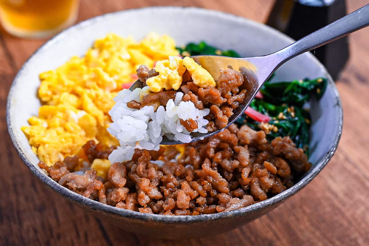 rice, soboro chicken and scrambled egg on a silver spoon