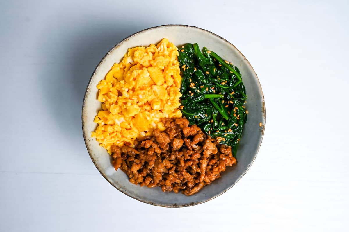 soboro chicken, scrambled egg and blanched spinach on top of rice