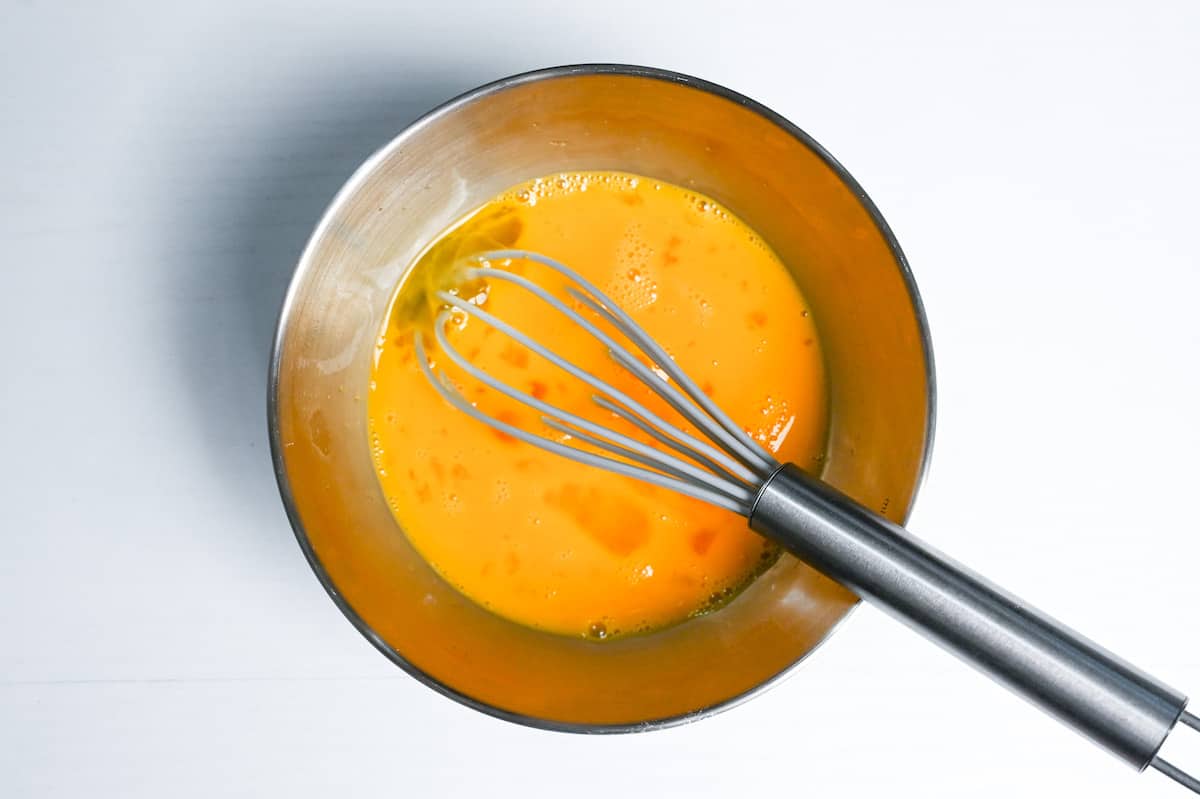 whisked eggs in a metal mixing bowl