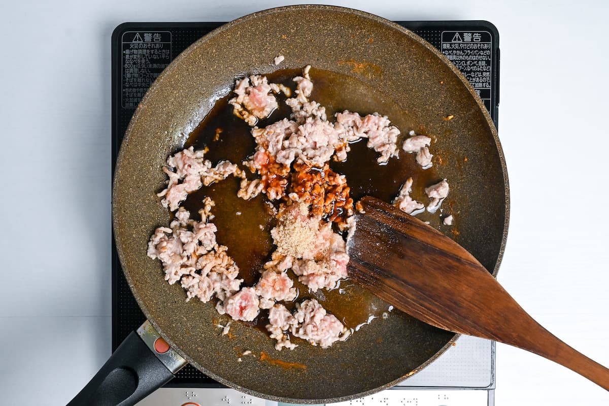 adding Japanese condiments to flavor soboro chicken