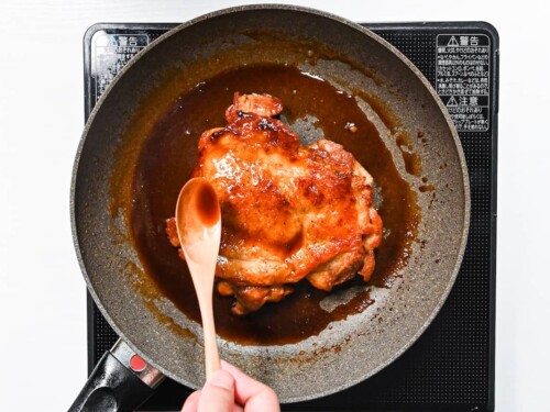 basting pan fried chicken thigh with teriyaki sauce