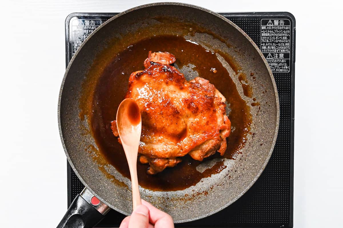 basting pan fried chicken thigh with teriyaki sauce