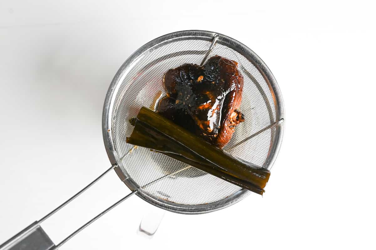 Straining dashi ingredients to make tsuyu sauce