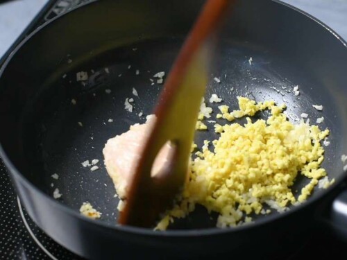 Frying finely diced garlic and ginger in a pan with beef fat