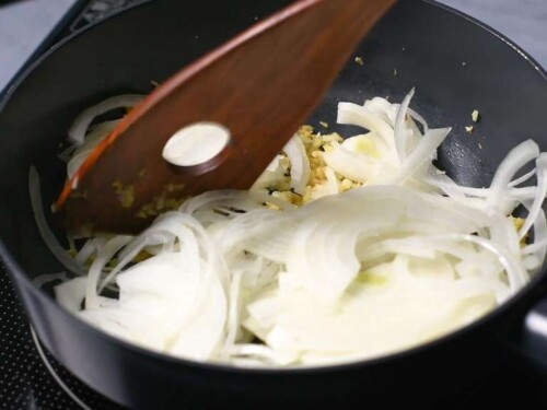 Adding sliced onions to the pan