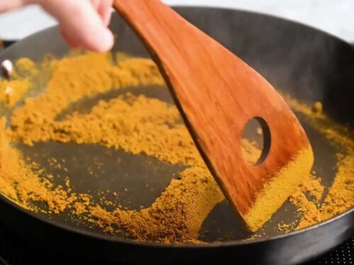 Toasting spices in a pan (curry powder and cumin)