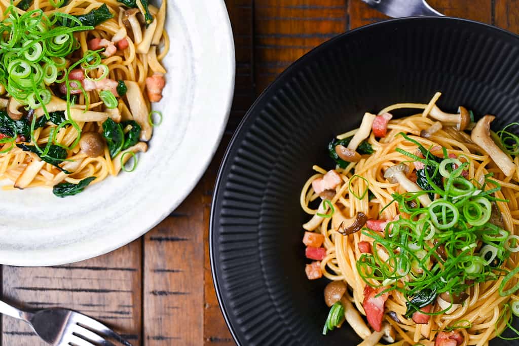 Japanese butter shoyu wafu pasta on black and white plates