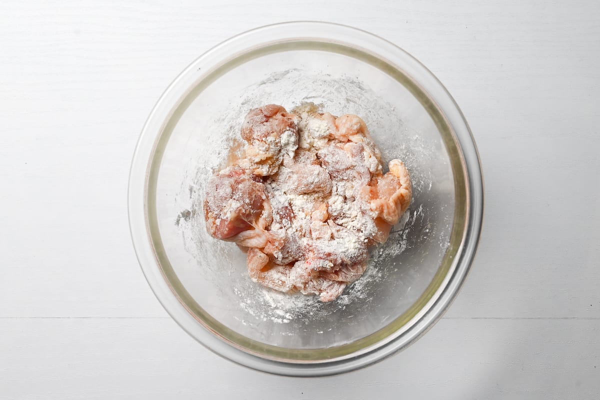 bitesize chicken thigh pieces coated in flour in a glass bowl