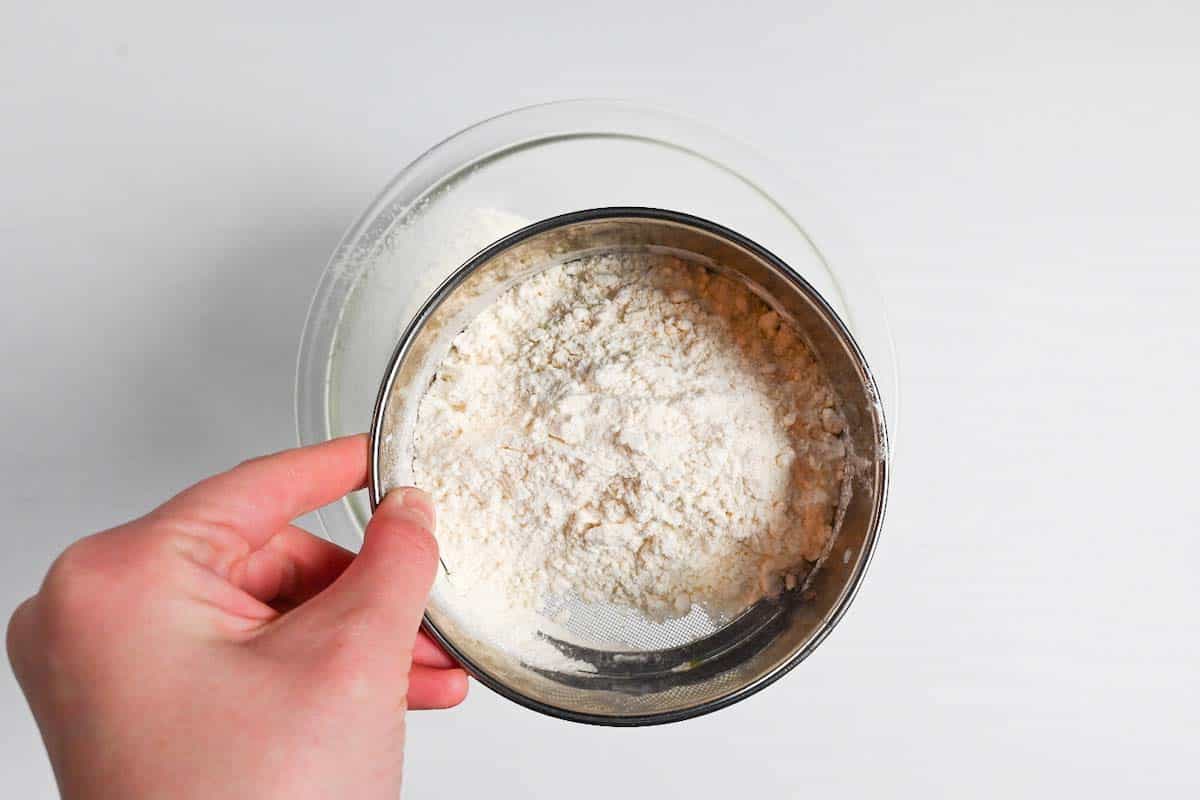 sifting flour into a glass mixing bowl