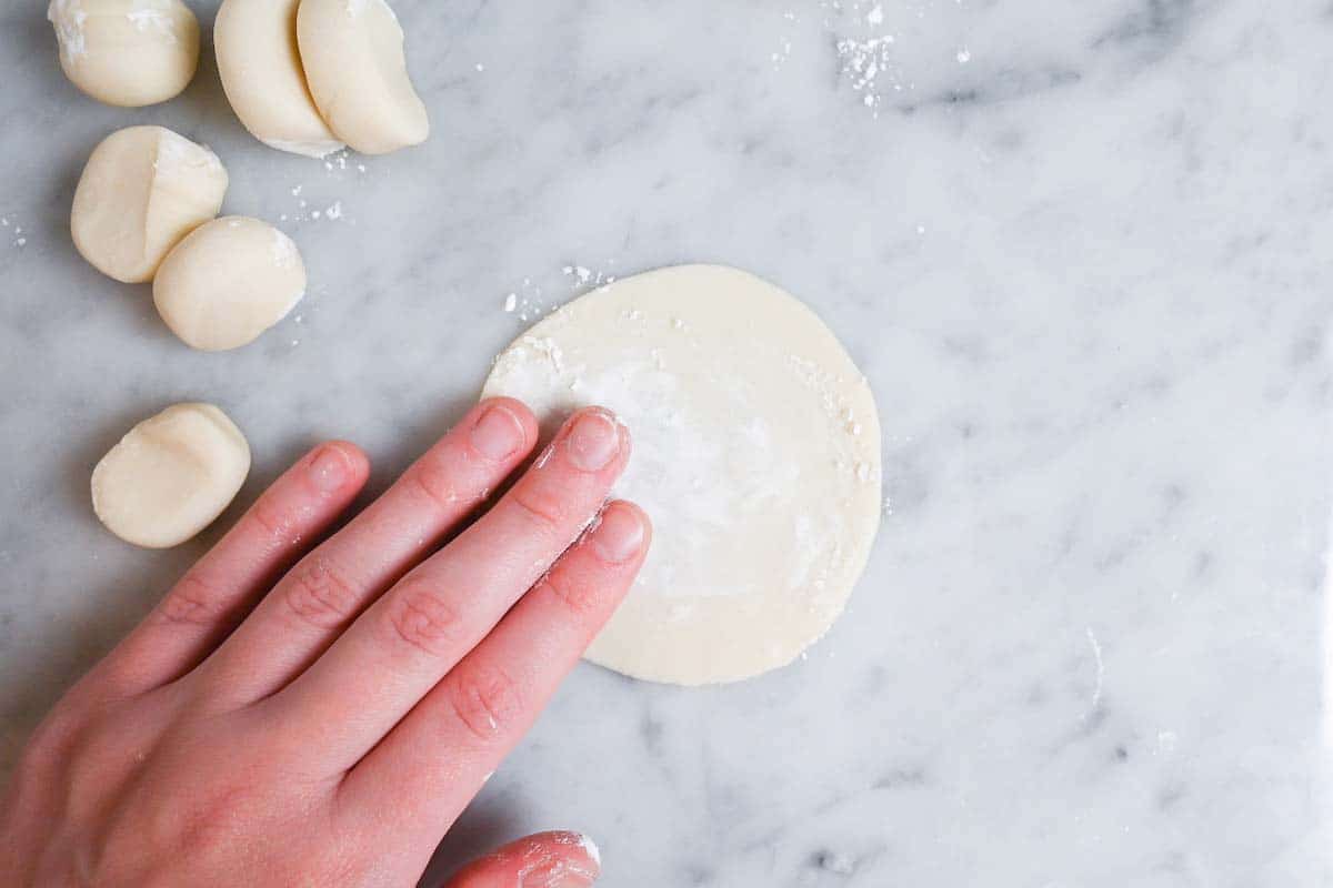 brushing the surface of gyoza wrapper with flour