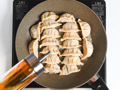 drizzling the top of the gyoza with sesame oil