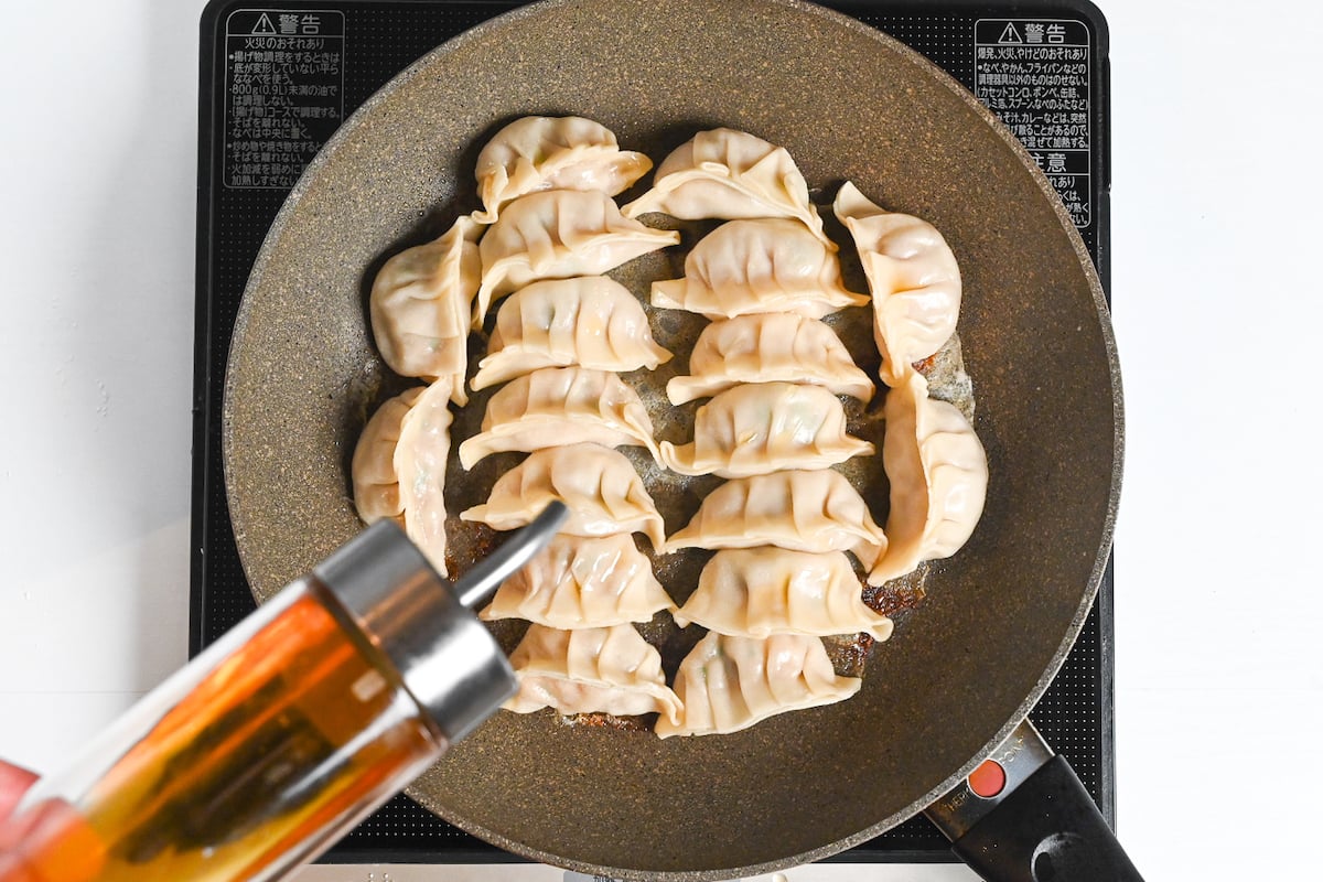 drizzling the top of the gyoza with sesame oil