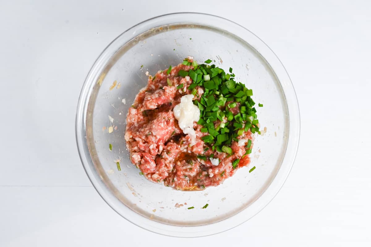 adding lard and chopped chives to gyoza filling