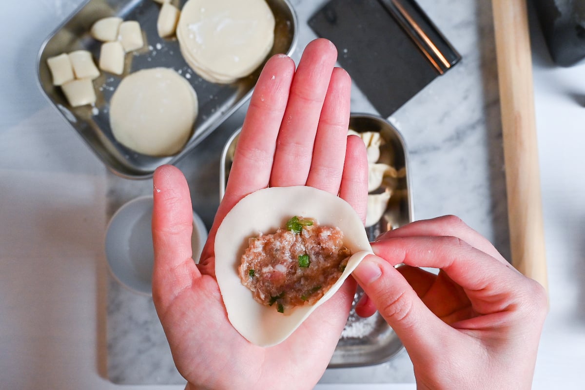 pinching the edge of the gyoza wrapper