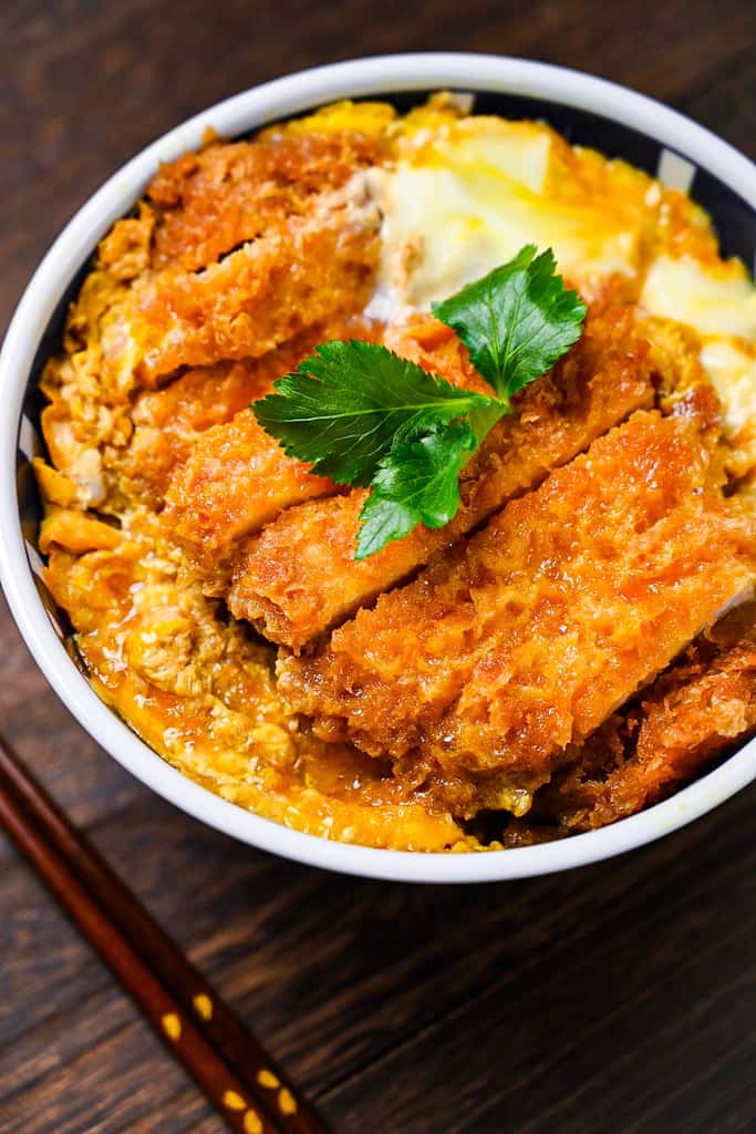 Japanese katsudon served in a blue and white bowl close up