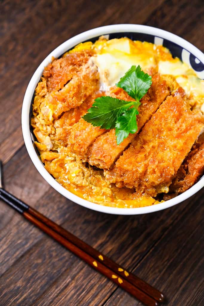 Japanese katsudon served in a blue and white bowl side view