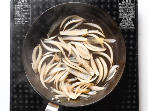 simmering onion in dashi broth for katsudon