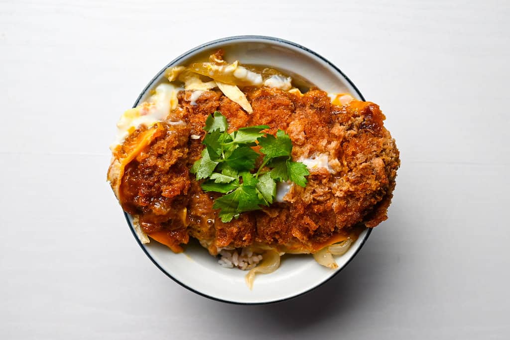 dishing up katsu and egg on rice