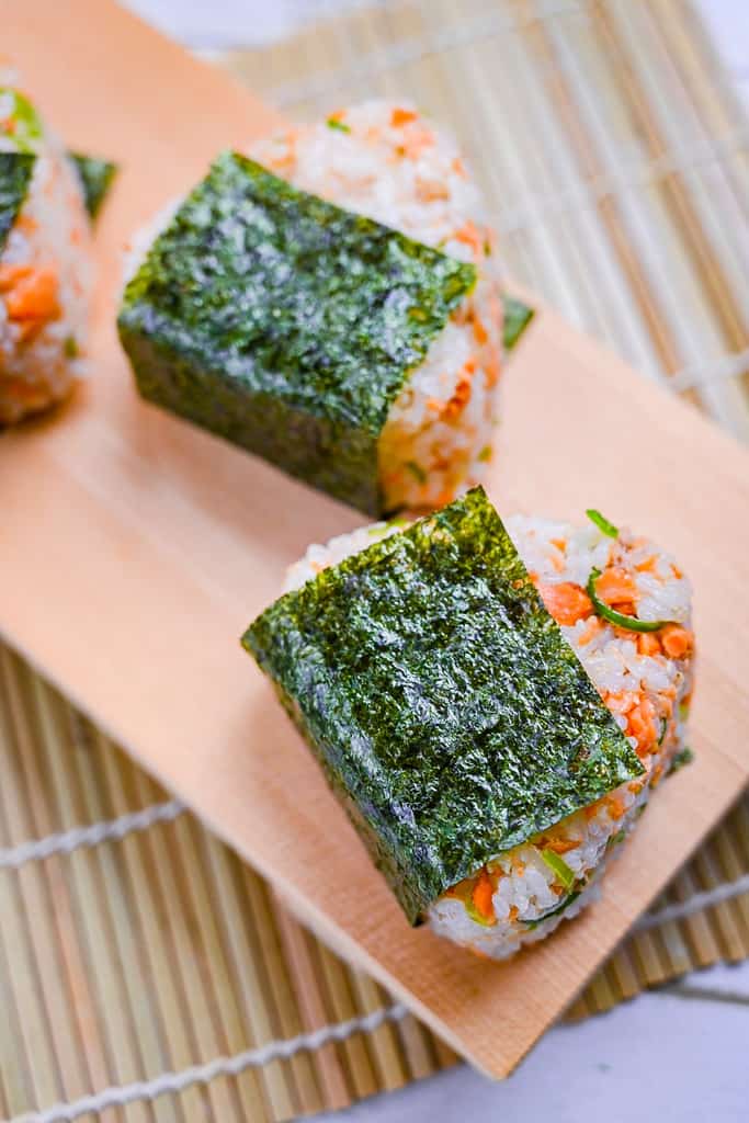 Butter soy sauce salmon onigiri rice ball with spring onion and sesame seeds