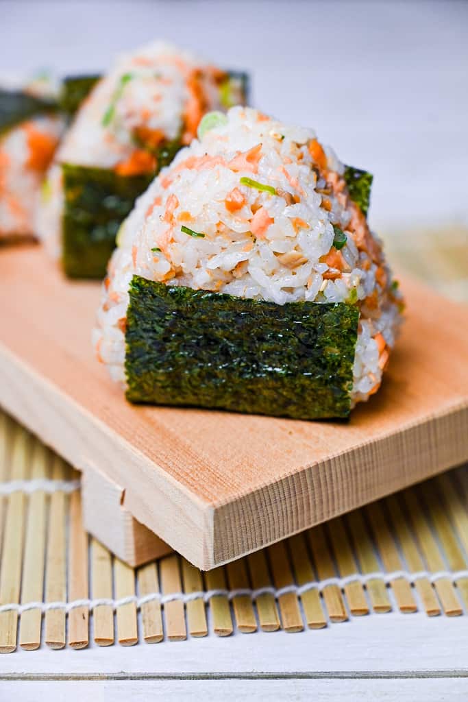 Butter soy sauce salmon onigiri rice ball with spring onion and sesame seeds