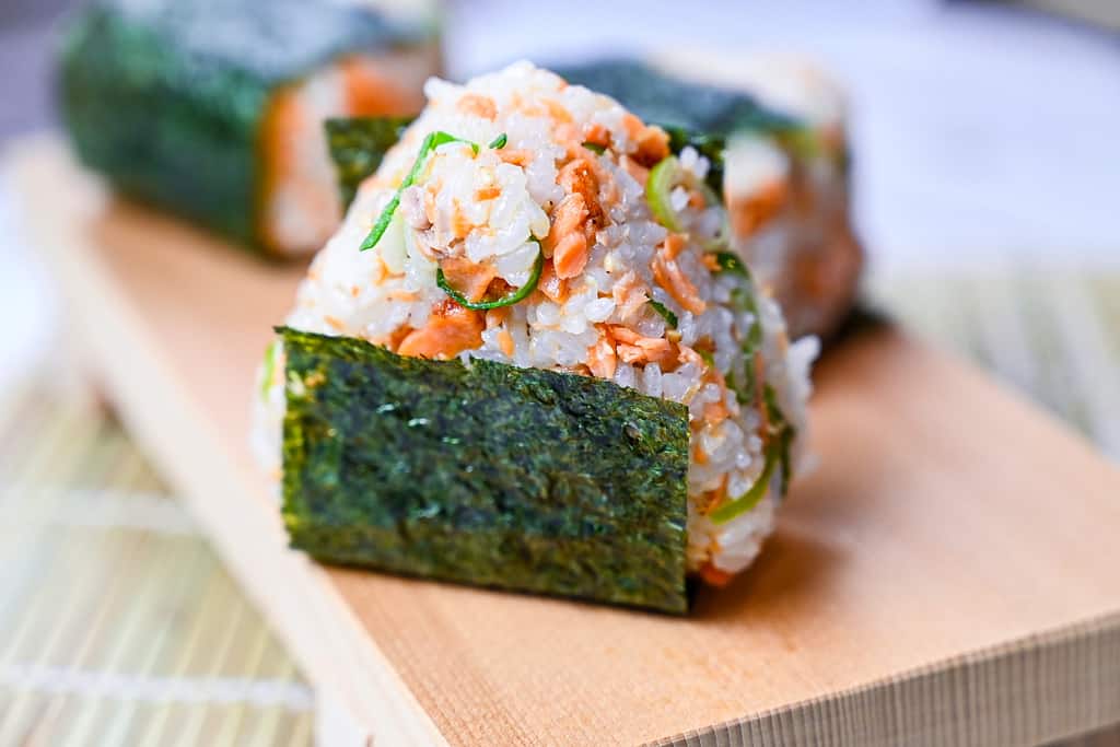 Butter soy sauce salmon onigiri rice ball with spring onion and sesame seeds