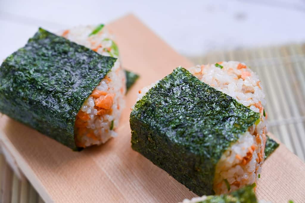 Butter soy sauce salmon onigiri rice ball with spring onion and sesame seeds