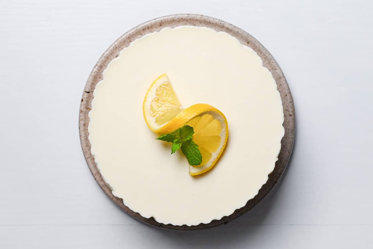 set rare cheesecake topped with lemon slice and mint leaves
