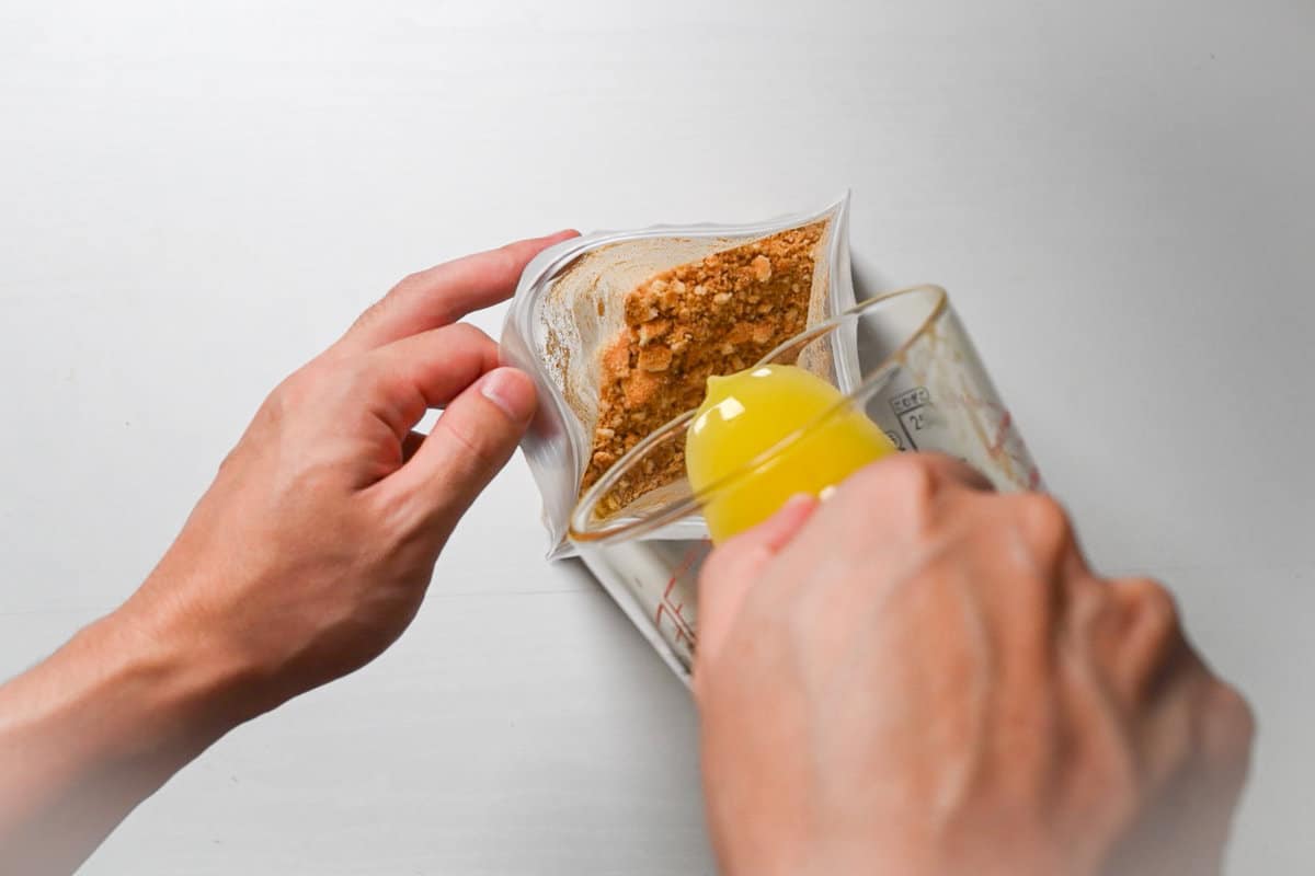 pouring the melted butter into the crushed biscuits