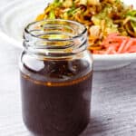 Yakisoba sauce in a jar with yakisoba noodles in the background