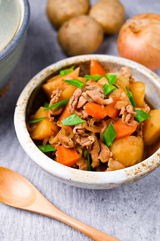 Japanese Nikujaga Meat and Potato Stew with ingredients and cooking pot