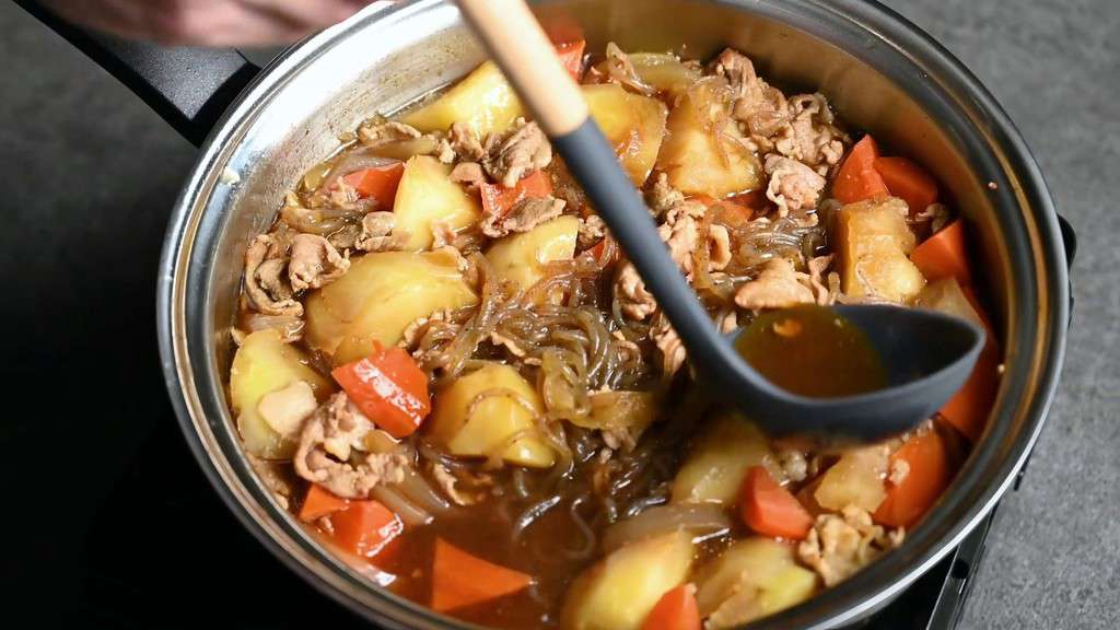 Spooning broth over ingredients