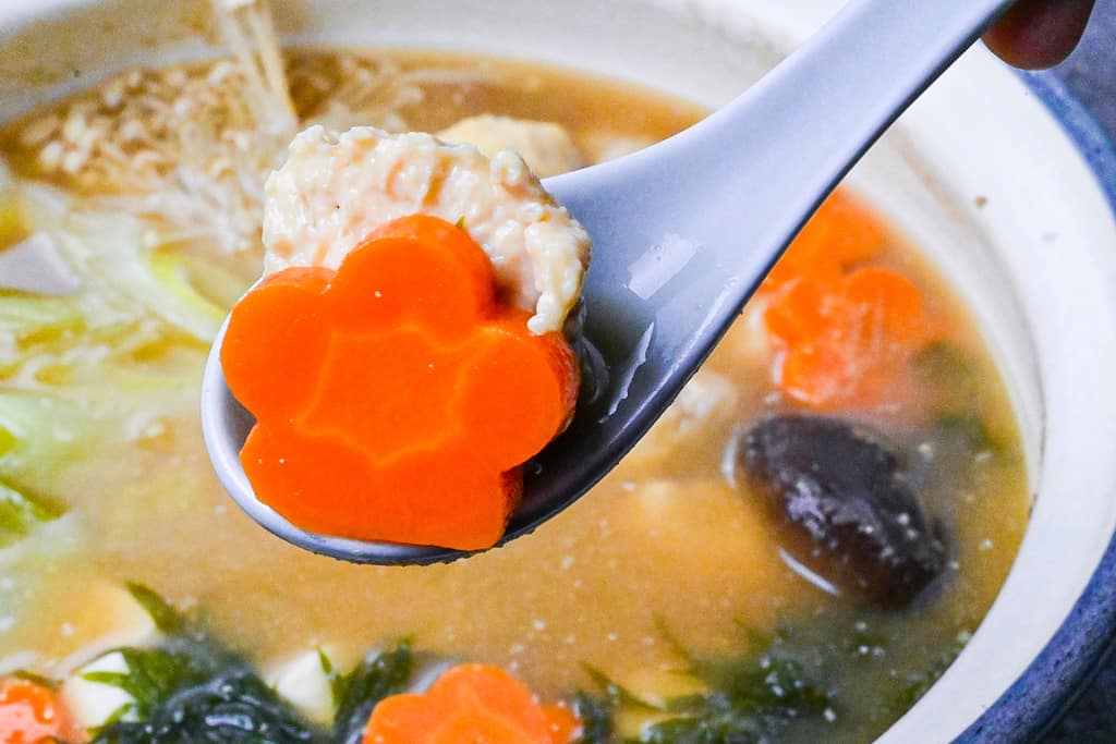 A flower shaped carrot and chicken meatball from sumo stew chanko nabe