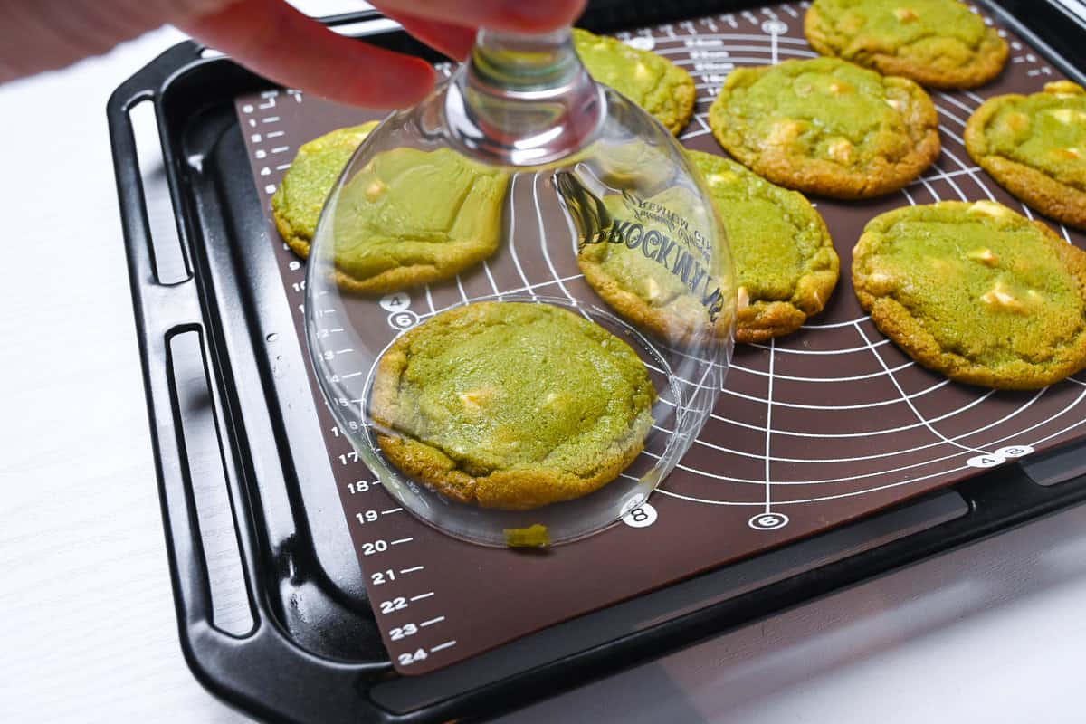 Perfecting the round shape of matcha and white chocolate cookies with a large glass