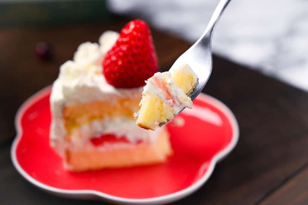 A bite of strawberry shortcake on a fork