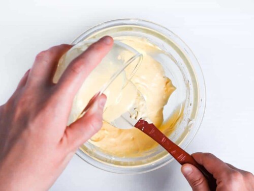 Pouring tempered milk and butter mixture into batter