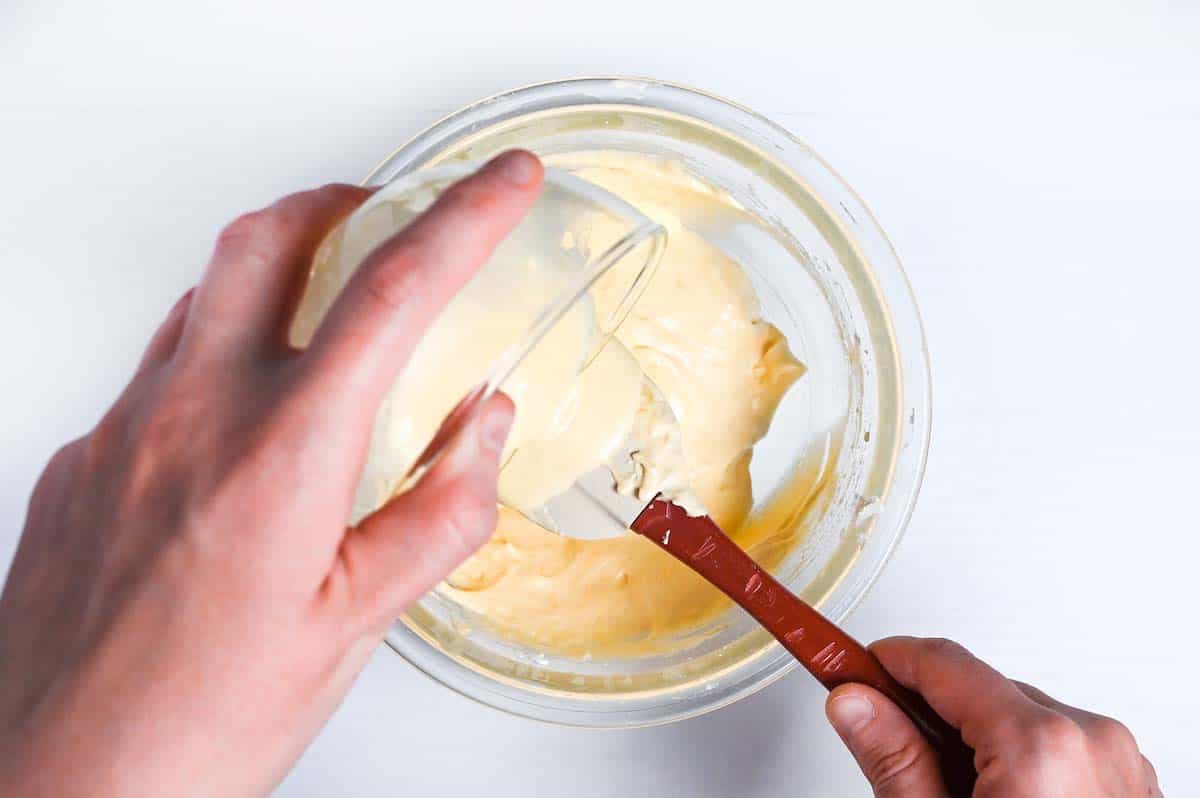 Pouring tempered milk and butter mixture into batter