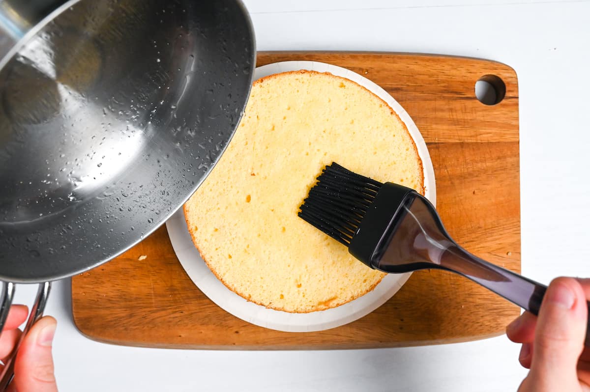 Brushing the top of the cake with syrup