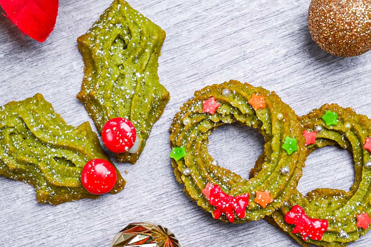 Matcha christmas cookies shaped into holly leaves and wreaths