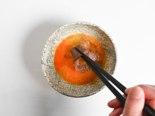 Dipping sukiyaki beef in whisked egg